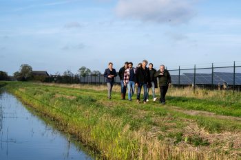 Wandelende mensen naast zonnepark Dokkum