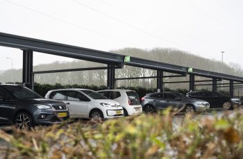 Een aantal auto's onder een zonnecarport